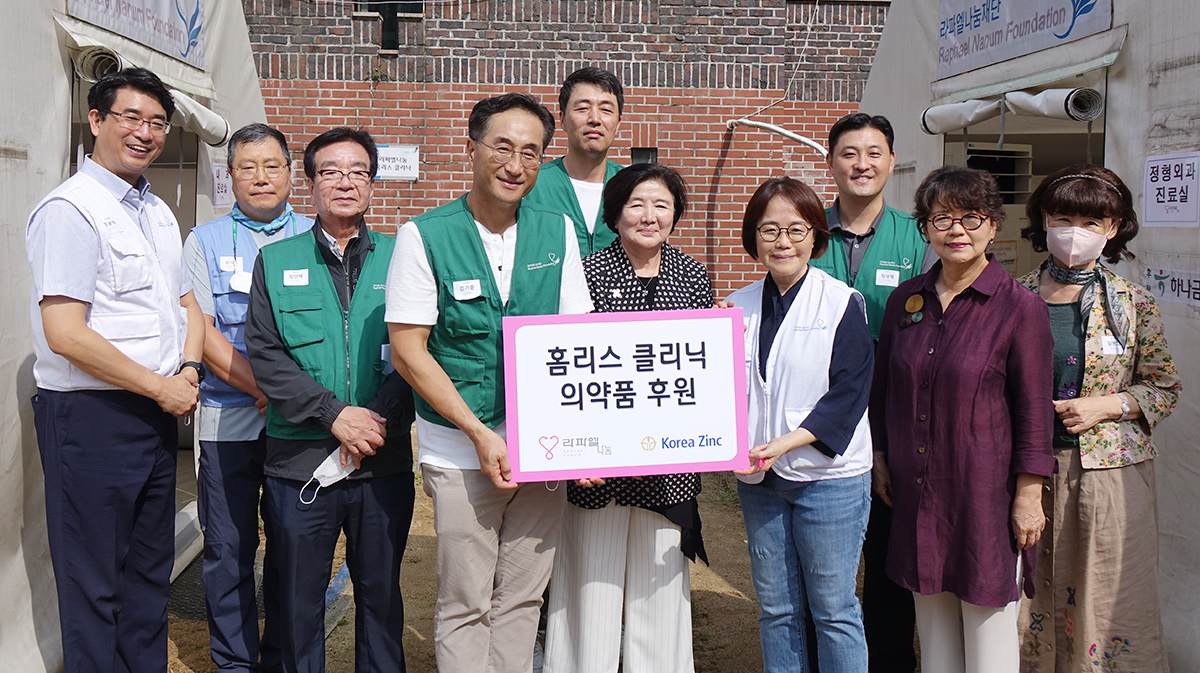 김기준 고려아연 지속가능경영본부장과 유중근 전 대한적십자사 총재가 봉사활동 이후 라파엘나눔재단 봉사자들 및 고려아연 임직원들과 기념촬영을 하고 있다. 